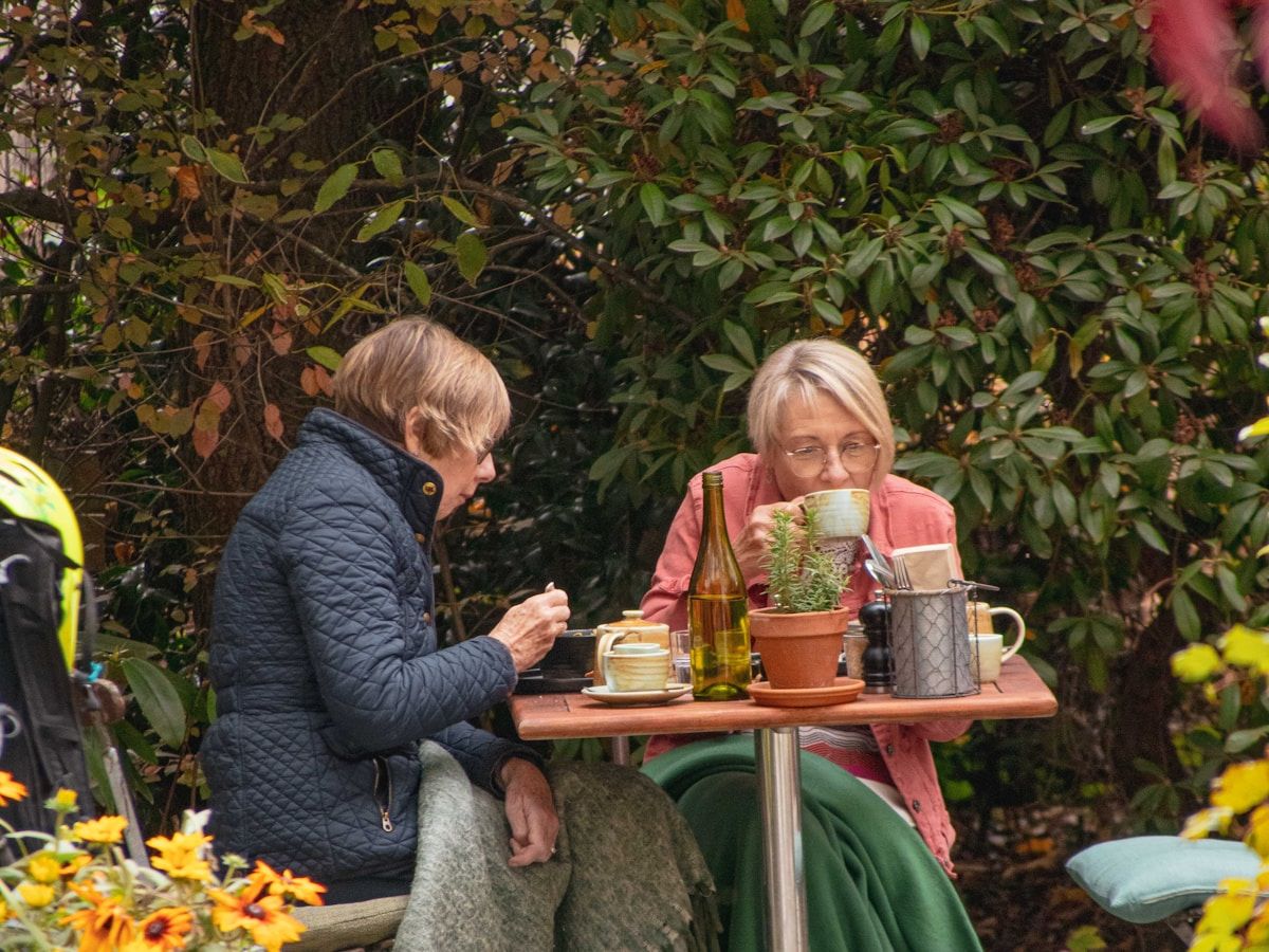 Two senior friends talking and laughing over afternoon tea