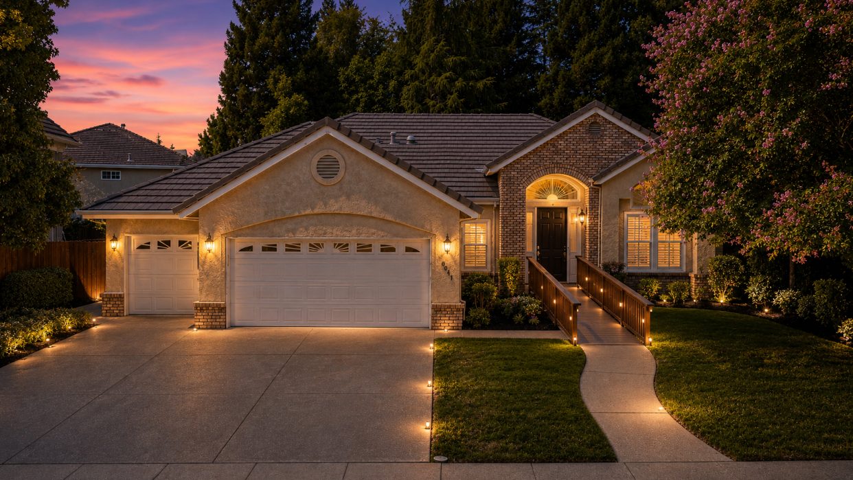 Golden-hour light on the tree-lined arrival drive of a residential home